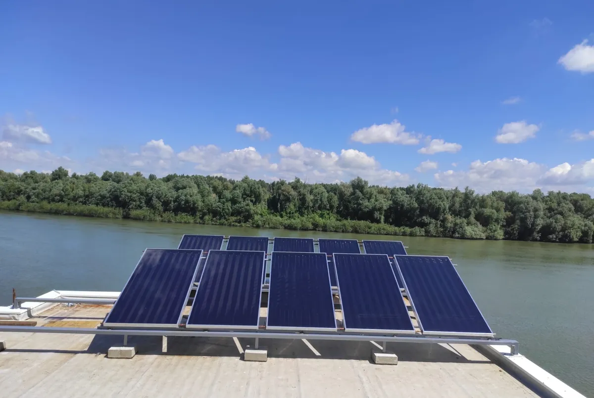 ELSOL flat solar collectors on a flat roof by the river