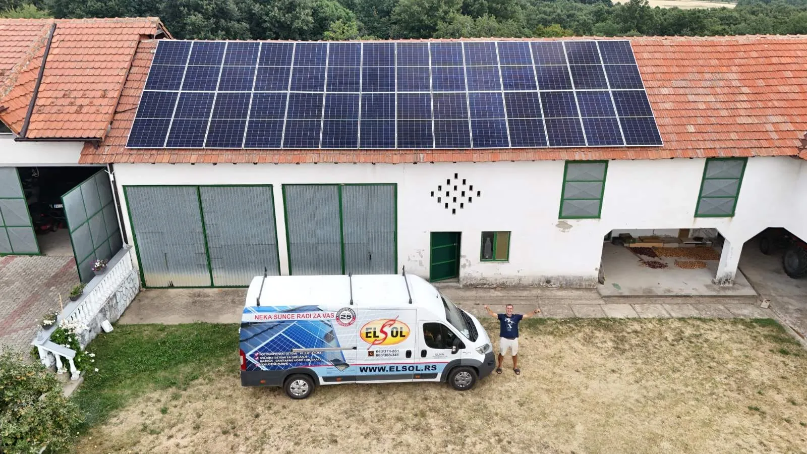ELSOL van in front of a farm building with a solar power plant on the roof, aerial shot
