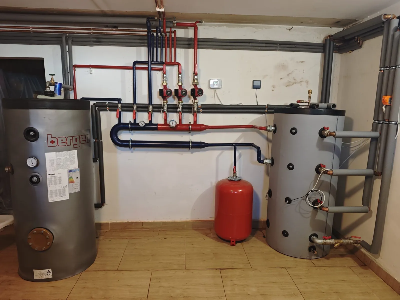 Boiler room with a solar water heater, a buffer tank and three pump groups