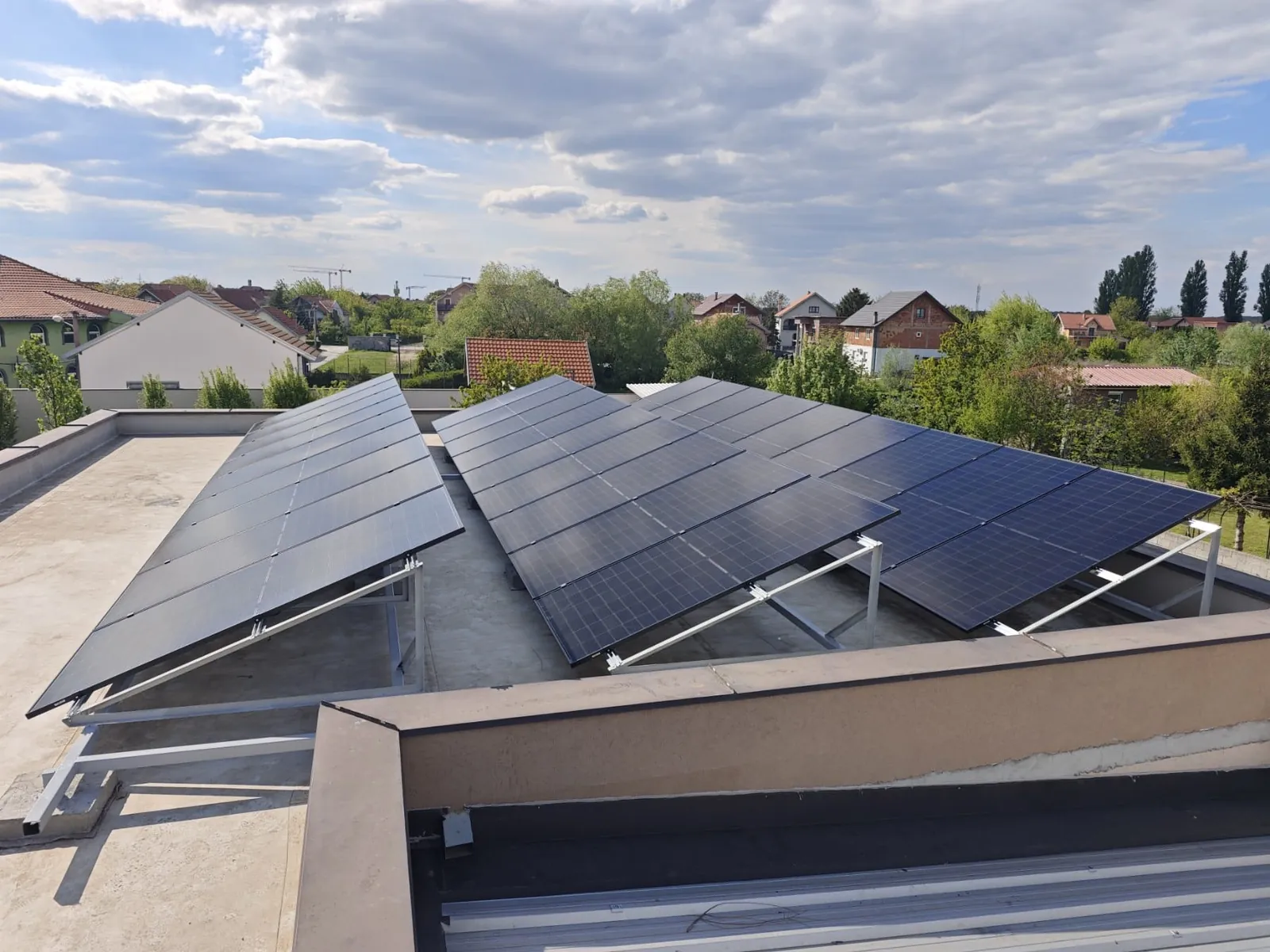 Solar panels on mounting frames on the flat roof of a family house