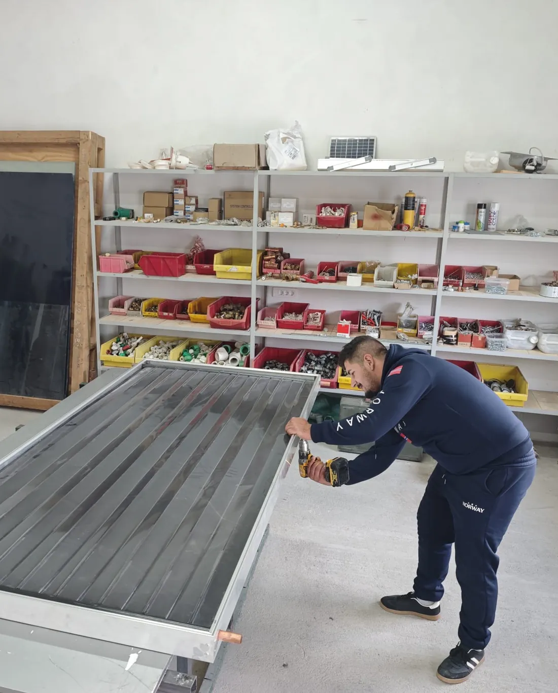 A worker in the ELSOL workshop assembling a flat solar collector